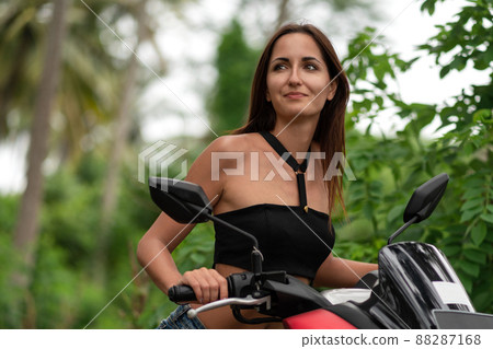 beautiful girl driving a scooter and she look into the distance.close-up 88287168
