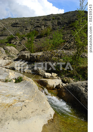 Long exposure view of a hidden river in Crimea, Ukraine. A stone set against a blurred water pattern is ideal for background use. 88289143