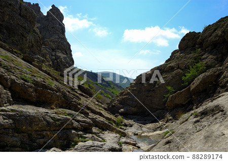 Long exposure view of a hidden river in Crimea, Ukraine. A stone set against a blurred water pattern is ideal for background use. Long exposure view of a hidden river in Crimea, Ukraine. A stone set against a blurred water pattern is ideal for background use. 88289174