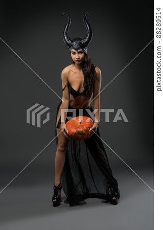 Sexy witch in black Halloween costume with pumpkin Sexy witch in black Halloween costume with pumpkin 88289514