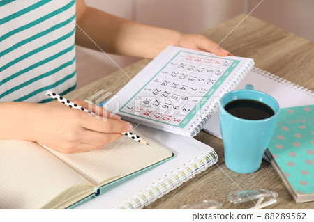 Woman making schedule using calendar at wooden table, closeup Woman making schedule using calendar at wooden table, closeup 88289562