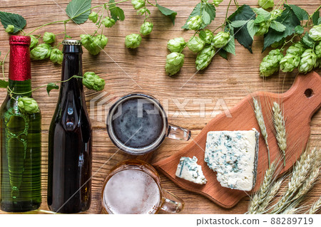 Beer background. Fresh beer and the salty cheese on a wooden table. Top view Beer background. Fresh beer and the salty cheese on a wooden table. Top view 88289719