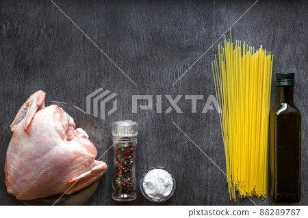 Pasta ingredients. Chicken breasts, spaghetti pasta on the wooden table. Space for text. Pasta ingredients. Chicken breasts, spaghetti pasta on the wooden table. Space for text. 88289787