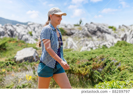 Young woman walking on trail in mountains on her summer vacation in europe 88289797