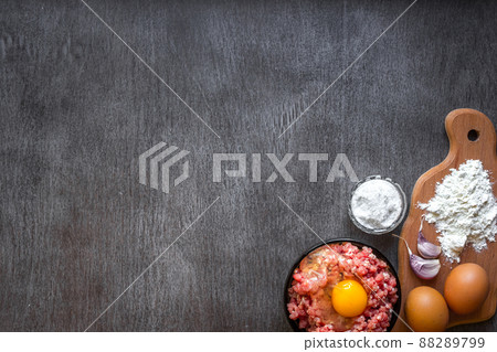 Raw minced meat with egg yolk, wooden cutting board on wooden background Raw minced meat with egg yolk, wooden cutting board on wooden background 88289799