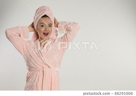 Beautiful young woman in bathrobe on light background. Space for text 88291008