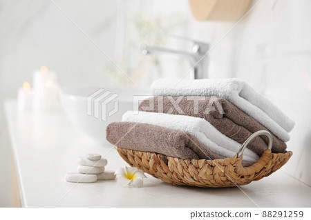 Basket with clean towels on counter in bathroom Basket with clean towels on counter in bathroom 88291259