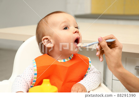 Young mother feeding her little baby at home 88291390