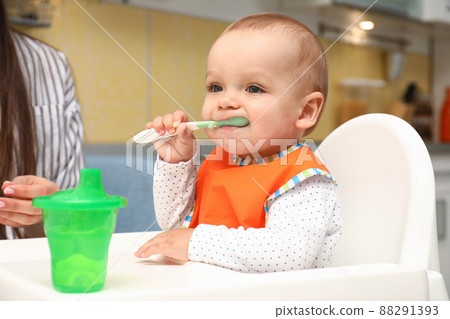 Young mother feeding her little baby at home Young mother feeding her little baby at home 88291393