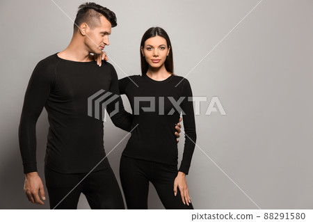 Couple wearing thermal underwear on grey background. Space for text 88291580