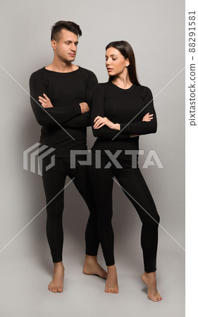 Couple wearing thermal underwear on grey background 88291581