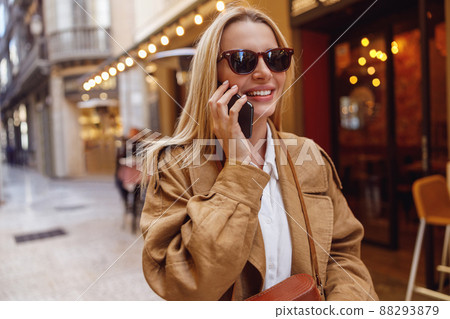 Portrait of lady in sunglasses calling by phone while standing on street 88293879