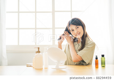 Middle-aged women looking in the mirror (brush, smile) 88294459