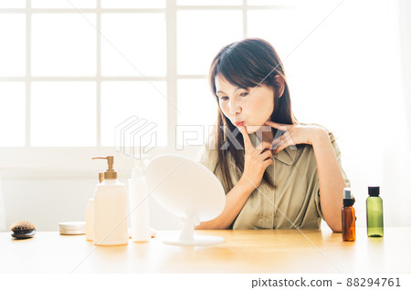 Middle-aged woman looking in the mirror (mouth) Middle-aged woman looking in the mirror (mouth) 88294761