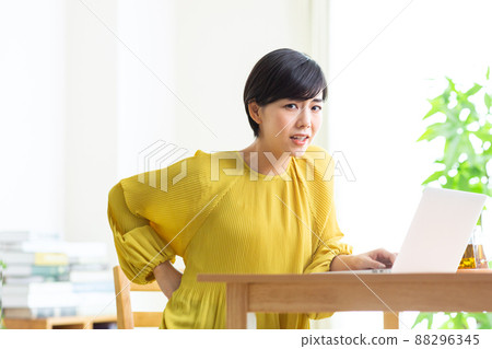 Young woman suffering from back pain Tired fatigue PC telework Young woman suffering from back pain Tired fatigue PC telework 88296345