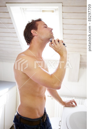 Getting ready for the day ahead. Handsome young guy shaving in his bathroom. Getting ready for the day ahead. Handsome young guy shaving in his bathroom. 88297709