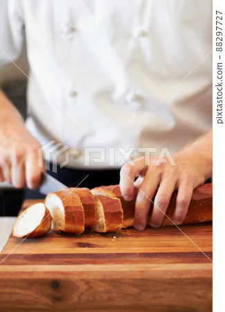 Presentation is everything. A baker cutting up french bread. 88297727