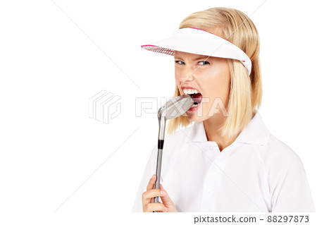 Golf can be so frustrating. Studio shot of an attractive female golfer biting down on her golf club in frustration isolated on white. 88297873