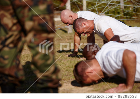 Youve gotta push through the pain. Shot of a group of men doing push-ups at a military bootcamp. 88298558