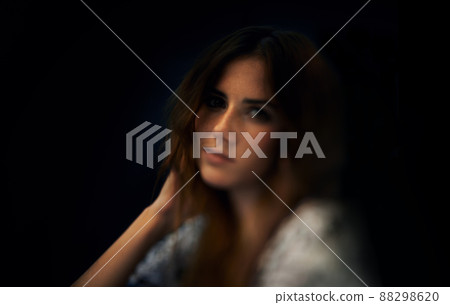 Femininity and style. A gorgeous young woman against a dark background. 88298620