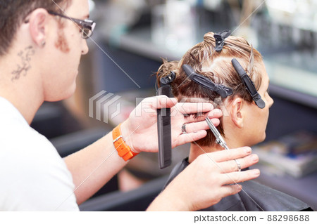 Giving her the perfect cut. A young woman getting a haircut at the hairdresser. 88298688