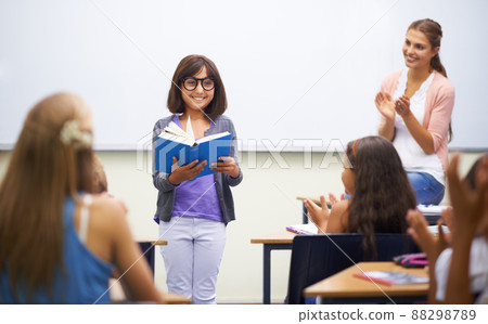 Prepared reading. A young girl doing prepared reading at the front of the class. Prepared reading. A young girl doing prepared reading at the front of the class. 88298789