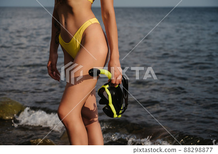 sexy slender body of a girl in a swimsuit with a mask and snorkel for diving on beach by sea 88298877