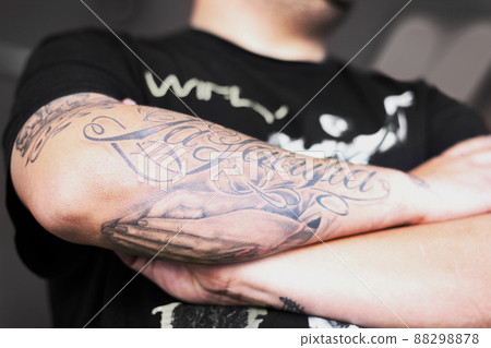 Badass with tattoos. Closeup shot of a man crossing his tattooed arms. 88298878