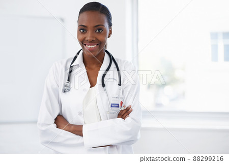 Medicine is her life. Portrait of a female doctor standing in a room with her arms crossed. Medicine is her life. Portrait of a female doctor standing in a room with her arms crossed. 88299216