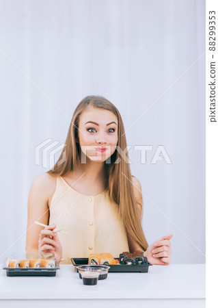 A funny girl on a white background for the first time tries sushi, space for text A funny girl on a white background for the first time tries sushi, space for text 88299353