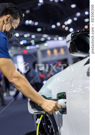 Hand holding Electric car charger. Hand holding Electric car charger. 88300306