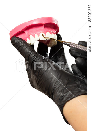Dentist's hands with layout of the human jaw and midical tool. Dentist's hands with layout of the human jaw and midical tool. 88301223