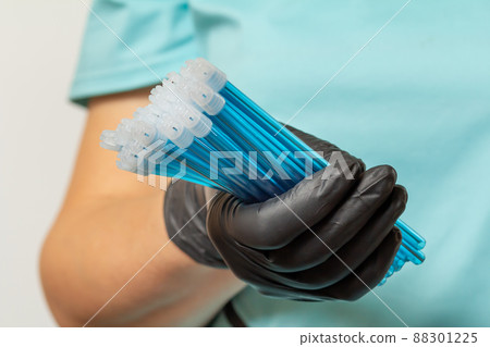 Dentist's hand in glove with saliva ejectors. Dentist's hand in glove with saliva ejectors. 88301225