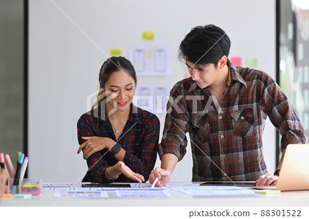 Two web designers planning and prototyping responsive design for mobile app. 88301522