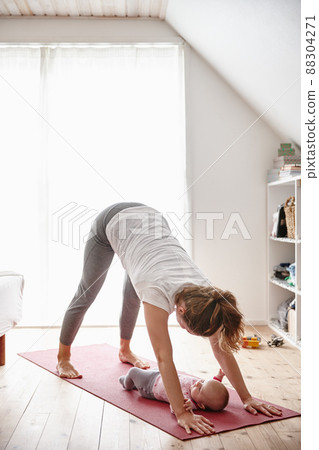 Peek-a-boo. Shot of an attractive young woman bonding with her baby girl while doing yoga. 88304271