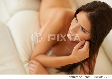 Composed natural beauty. Cropped shot of a sexy young woman lying nude on a sofa at home. 88304272