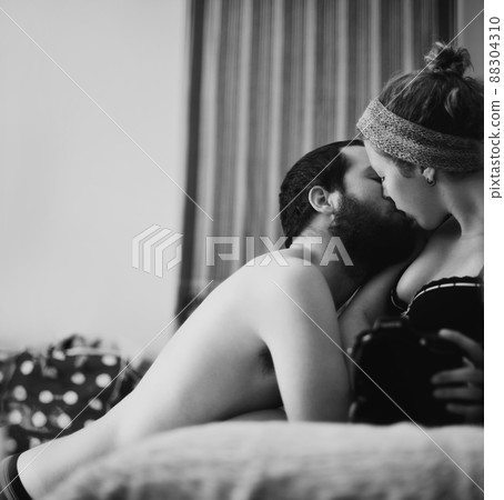 Candid passion. The reflection of a passionate couple kissing taken by their camera. 88304310