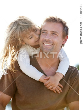 Every moment with her is precious. A young father carrying his smiling daughter on his back. 88304412