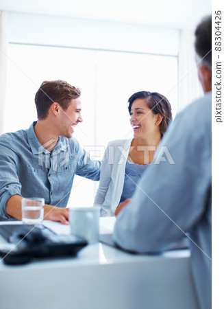 Happy couple discussing with advisor. Portrait of happy couple laughing while discussing with financial advisor. Happy couple discussing with advisor. Portrait of happy couple laughing while discussing with financial advisor. 88304426