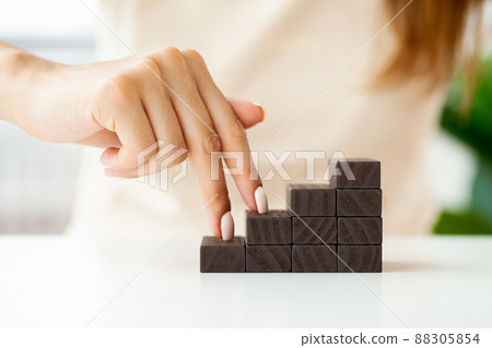 Hand stacking wooden black blocks for in shape of staircase. Hand stacking wooden black blocks for in shape of staircase. 88305854