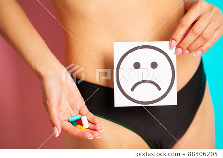 Close up of woman having female health problems holding card with sad smile Close up of woman having female health problems holding card with sad smile 88306205