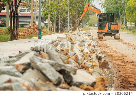 Drilling and demolishing the concrete pavement of the roadside pavement. Drilling into the pavement with a big truck is a very good machine. Drilling and demolishing the concrete pavement of the roadside pavement. Drilling into the pavement with a big truck is a very good machine. 88306214