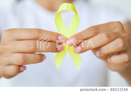 Yellow ribbon in hands, symbol Bladder cancer Yellow ribbon in hands, symbol Bladder cancer 88311536