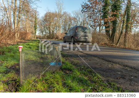 Fence on a road to protect batrachians during their spring migration. Fence on a road to protect batrachians during their spring migration. 88313360