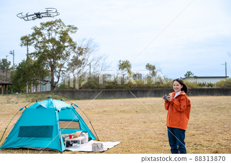 在露營地享受無人機航拍的年輕女子 88313870