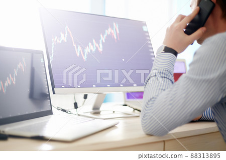 manager looking at the monitor and talking on the phone manager looking at the monitor and talking on the phone 88313895