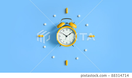 Alarm Clock with pills, medical capsules on blue background Alarm Clock with pills, medical capsules on blue background 88314714