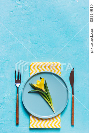 Spring table setting with yellow flower in a plate 88314919