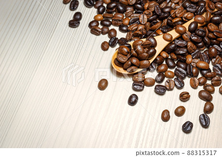 Coffee beans in wooden spoon on a light table Coffee beans in wooden spoon on a light table 88315317