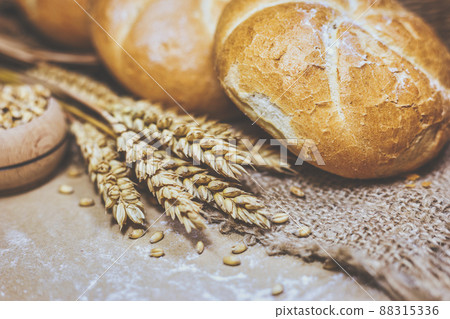 Fresh bread and wheat on a rustic background 88315336